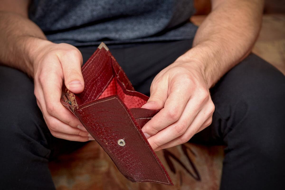 Mężczyzna trzymający w dłoniach otwarty portfel