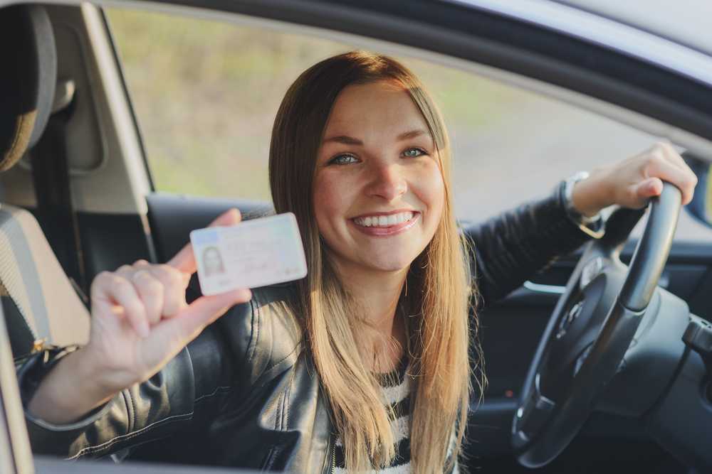 Kobieta pokazująca norweskie prawo jazdy